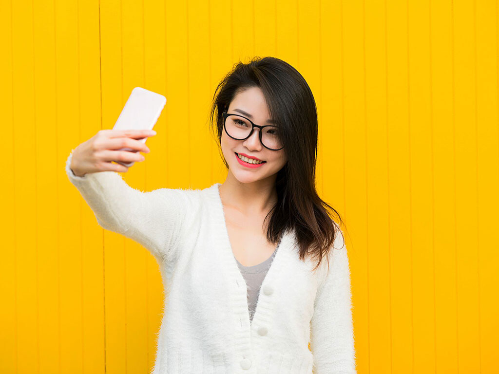 Woman taking selfie with smartphone