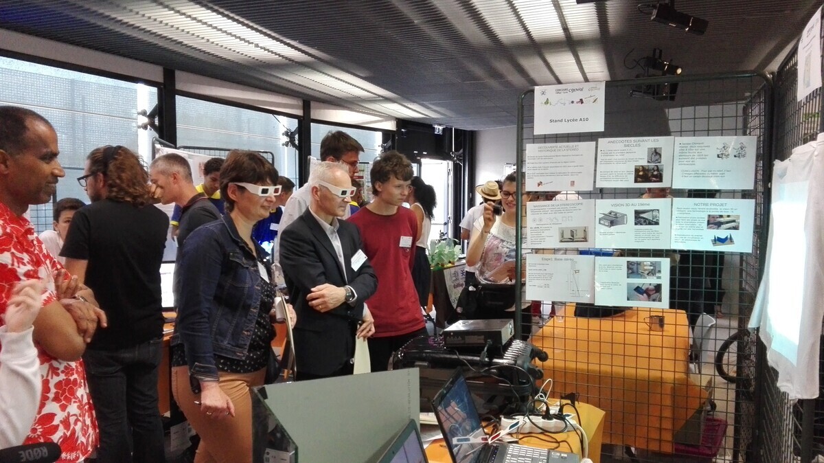 Des membres du jury devant le stand d'élèves lors de la finale du Concours CGénial 2018 - © Fondation CGénial